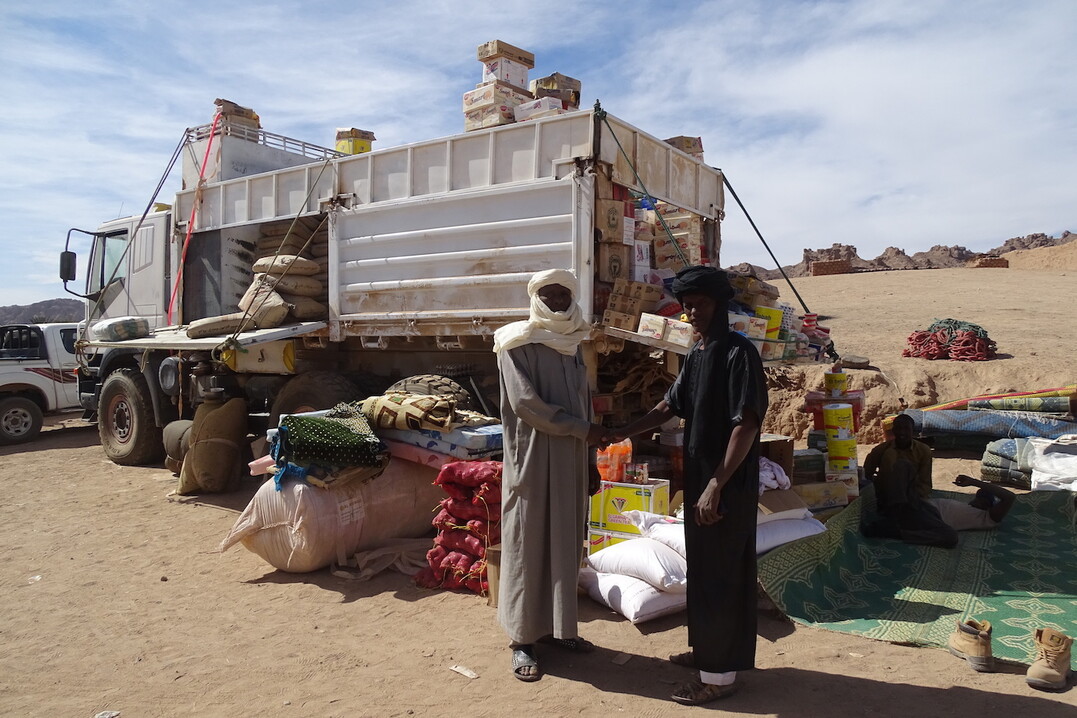 Der Markt von Bardai. Dieser Hndler verkauft Zwiebeln, Matratzen, Kekse, Bonbons, Konserven, Guavensaft, Milchpulver, Matten, Tee, Zement, Zucker, Kse und Gebetsteppiche. Viele Gter werden ber Libyen importiert.   