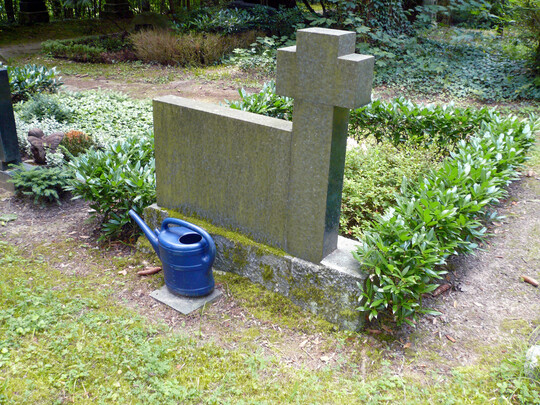 Aus Nutzersicht praktisch, aber unschön ist es, Kannen hinter dem Grabstein zu lagern.