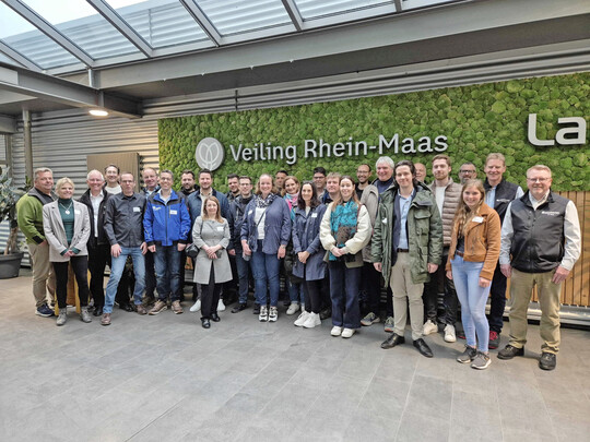 Die Besuchergruppe von Agrobusiness Niederrhein im großzügig begrünten Foyer der Veiling Rhein-Maas.