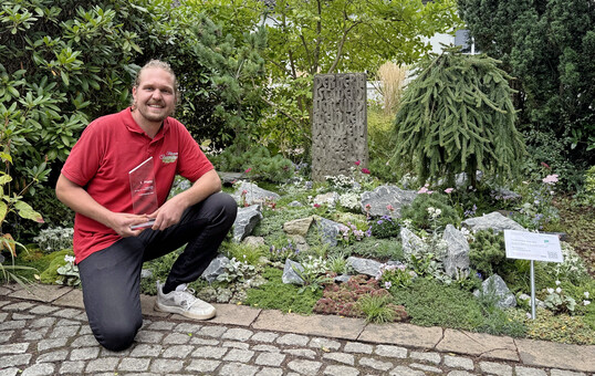 Wettbewerbssieger Markus Biermann (Moers) vor dem von ihm gestalteten Grab „Die Gipfelstürmerin“.