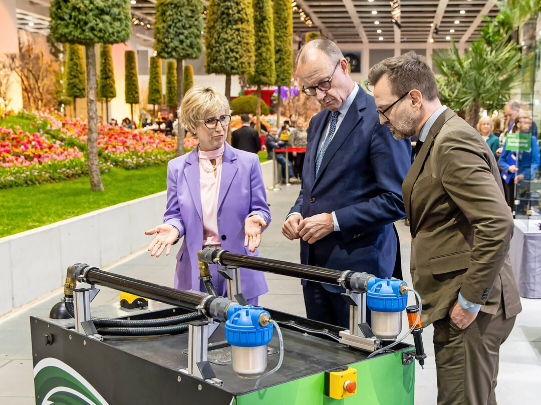 ZVG-Pr�sidentin Eva K�hler-Theuerkauf und ZVG-Gesch�ftsf�hrer Bertram Fleischer zeigten Bundeskanzler Friedrich Merz anhand eines modernen Bew�sserungsroboters, wie Digitalisierung und Effizienz im modernen Gartenbau zusammenkommen.