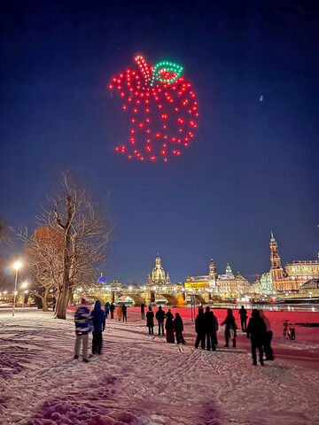 Ab 18 Uhr formierten hunderte Drohnen über dem Elbufer gigantische Apfel-Silhouetten, klare Aussagen und Bildmotive – inszeniert vor der Kulisse der Altstadt und in unmittelbarer Nähe eines der größten deutschen Apfelanbaugebiete.