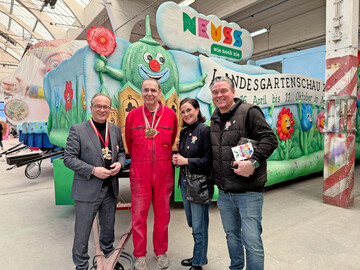 Der D�sseldorfer Wagenbauer Jacques Tilly (2. von links) hat den Karnevalswagen der Landesgartenschau Neuss entworfen und mit seinem Team gebaut. Beim traditionellen Richtfest in der D�sseldorfer Wagenbauhalle hat er den Mottowagen dem Neusser B�rgermeister Reiner Breuer (links), Sandra Maria Breuer vom Mitmachverein Gr�nes Herz Neuss (2. von rechts) und Wagenmeister Tobias Krins von Neuss Marketing (rechts) vorgestellt.