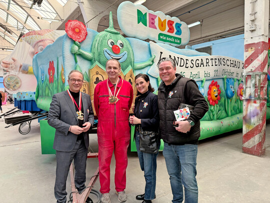 Der D�sseldorfer Wagenbauer Jacques Tilly (2. von links) hat den Karnevalswagen der Landesgartenschau Neuss entworfen und mit seinem Team gebaut. Beim traditionellen Richtfest in der D�sseldorfer Wagenbauhalle hat er den Mottowagen dem Neusser B�rgermeister Reiner Breuer (links), Sandra Maria Breuer vom Mitmachverein Gr�nes Herz Neuss (2. von rechts) und Wagenmeister Tobias Krins von Neuss Marketing (rechts) vorgestellt.
