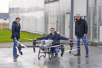 Dr. Anke Schirocki und Marcus Trappe (rechts) lassen sich von Sebastian Hylewicz die Agrardrohne zur Schattierung von Gew�chsh�usern vorf�hren.