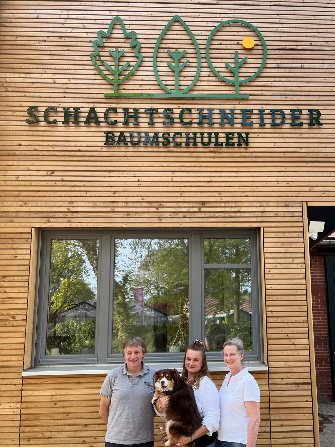 Familienfoto vor dem neuen Firmenschild  Udo, Marie-Luise mit Hund Ida und Susanne Schachtschneider