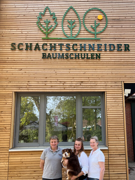 Familienfoto vor dem neuen Firmenschild  Udo, Marie-Luise mit Hund Ida und Susanne Schachtschneider