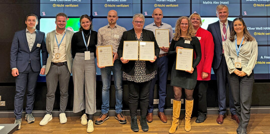 berreichung der Zertifikate bei einem Statusworkshop von MCS am 10. Oktober 2024 in Berlin, von links: Simon Busse (FNR); Markus Bockholt (MCS); Katrin Jaeger (MCS); Jonas Velz (Eifel-Holz), Ulrike Fockenberg (Gramoflor); Marc van Dael (Copertiz); Ribanna Jansen (toom Baumarkt); Cornelia Berns (BMEL); Dr. Norbert Schmitz (MCS); Julia Ostrowski (MCS).