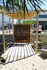 Der Themengarten hat mehrere Sitzplätze - hier das überdachte Klinkerpodest mit Sitzbank in der hinteren Ecke des Gartens.