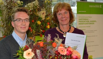 Studentenvertreter Jan Philipp Knig berreicht Urkunde und Blumen an Preistrgerin Katrin Kell.