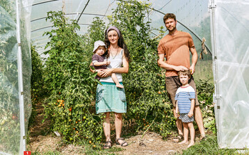 Aline Schreyer und Hendrik Nomann mit ihren beiden Kindern im Tomatengewchshaus.