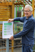 Hermann Berchtenbreiter bringt die neuesten Corona-Schutzhinweise an.