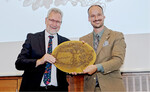 Staffelstabübergabe im Vorstandsvorsitz: Manfred Klunke (links) übergibt ein historisches Messingschild mit dem Leitspruch Einer für alle, alle für einen" an seinen Nachfolger Christian Senft.
