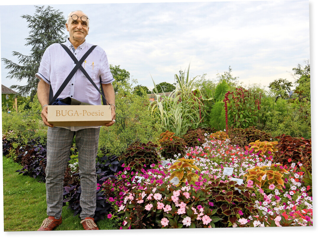 Der Blumenhallendichter José Oliver mit seinem wichtigsten Werkzeug, dem Bauchladen mit der BUGA-Poesie.