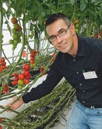 1 Peter Tiede-Arlt am Belüftungssystem im Versuchsgewächshaus.