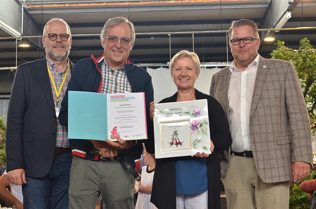 So schne Fuchsien, das durfte nicht ungeehrt bleiben, befand die Deutsche Fuchsien-Gesellschaft und deswegen berreichten Klaus Gtz (von links), Prsident des Fachverbands Deutscher Floristen Landesverband Baden-Wrttemberg, Hans-Jrgen Schnur, Vorsitzender der Deutschen Fuchsien-Gesellschaft, und Rdiger Eckhardt, Ausstellungsbevollmchtigter der DBG, Rosi Friedl und ihrer Fuchsiengrtnerei aus Markt Indersdorf einen Ehrenpreis fr ihre besonderen Fuchsiensolitrformen, die alle Blicke auf sich ziehen.
