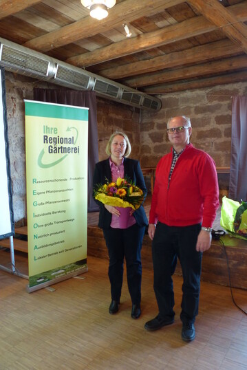 Der 1. Vorsitzende der Interessengemeinschaft Ihre RegionalGrtnerei, Karl Menger, bedankt sich mit einem grtnerischen Gru bei Anke Wehking, Landesanstalt fr Landwirtschaft in Freising.