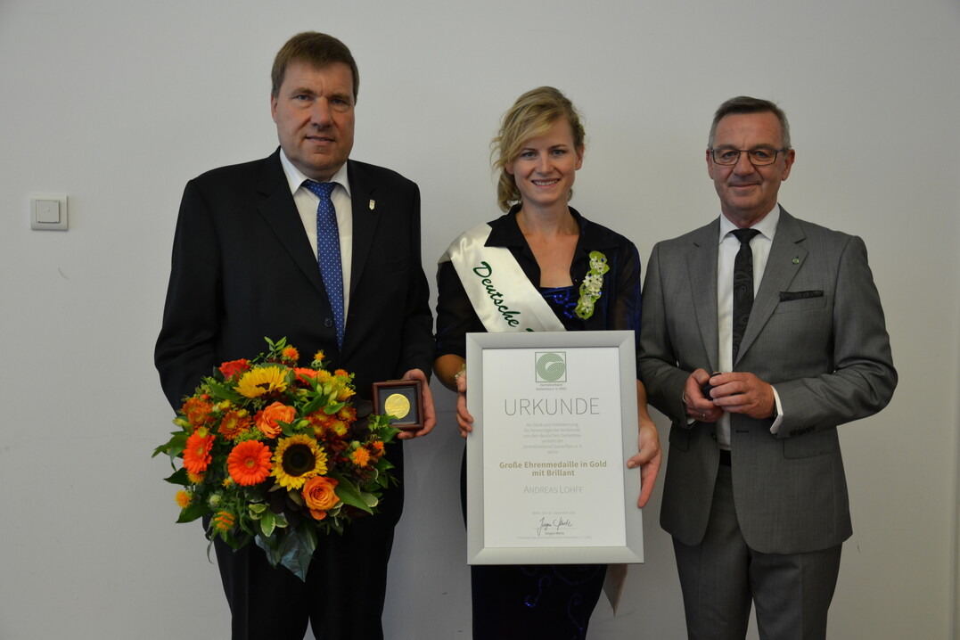 ZVG-Präsident Jürgen Mertz (rechts) verlieh Andreas Lohff die Große Ehrenmedaille in Gold mit Brillanten. Blumen überreicht die frisch gekürte Blumenfee Corina Krause.