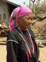 Eine rauchende Akka-Frau in ihrer typischen Tracht.