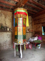 In einem Kloster außerhalb von Zhongdian fotografierte ich diese etwas "handlichere" Gebetsmühle. Am oberen Rand des Zylinders kann man die Glocke erkennen, die beim Drehen in Bewegung versetzt wird und damit nach jeder Umdrehung ein neues Gebet ankündigt. Alle in der Walze befindlichen Mantras (Gebete) sollen durch die Drehung Licht in jede Richtung und somit zu allen fühlenden Wesen ausstrahlen, deren Leid beseitigen und ihr schlechtes Karma auflösen.