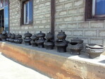 In jedem chinesischen Haushalt befinden sich solche "Black Pottery"-Gefäße. Die schwarze Färbung entsteht durch ein spezielles Verfahren am Ende des Brennprozesses, welches in China vor etwa 10000 Jahren entwickelt wurde. In der großen unteren Schale wird ein Feuer entfacht, darauf kann man kochen, Teewasser erhitzen oder ganz einfach Wärme für die darum herum Sitzenden erzeugen.
