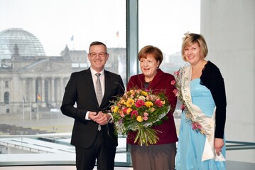 ZVG-Prsident Jrgen Mertz und Blumenfee Alexandra Berchtenbreiter berbringen Bundeskanzlerin Angela Merkel die traditionellen Valentinsgre des ZVG.