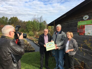 Die Lilienarche in Erlangen wird mit der Natur im Garten Schaugarten-Plakette ausgezeichnet. (v.l.n.r.) Siegmund Schauer, Prsident Verband Wohneigentum Landesverband Bayern, Stefan Strasser, Lilienarche Erlangen, und Landschaftsarchitektin Dorle Engels 