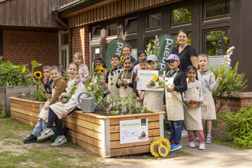 Gemeinsam mit Schulleiterin Ute Hickmann und der betreuenden Lehrerin Leonie Finnern haben Mdchen und Jungen der Kirsten Boie Schule in Barsbttel im Mai 2023 ihren neuen Schulgarten in Betrieb genommen.