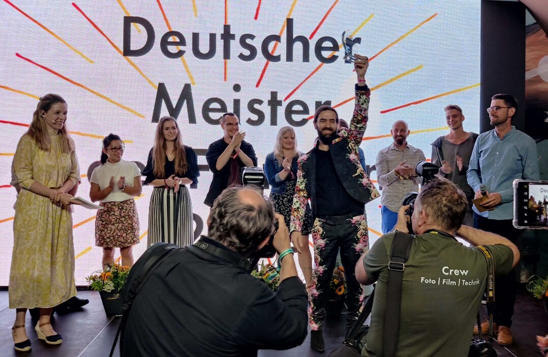Siegerehrung in Berlin. Der Pokal wurde von Michael Liebrich, dem Deutschen Meister der Floristen 2018, berreicht.