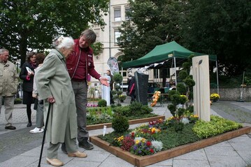 Ein Friedhofsgrtner bert auf dem Tag des Friedhofs eine Besucherin ber kreative Grabgestaltung.
 