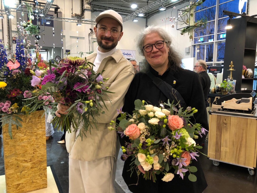Oliver Ferchland and Kerstin Dallmann with bouquets for the winners of the Best Practice Award.